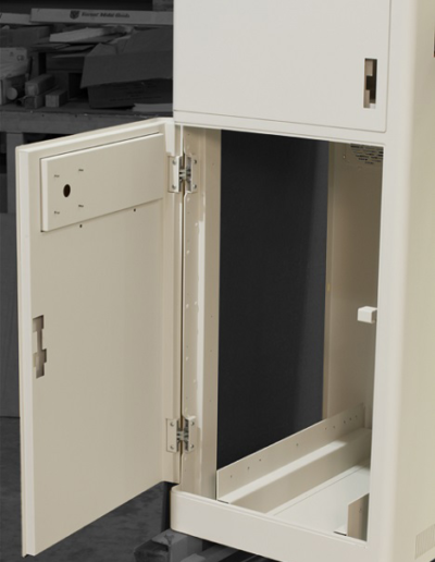 A precision electronics enclosure with comlex hinges, flush-closing doors, double-skinned walls, rounded exterior corners, and textured paint.